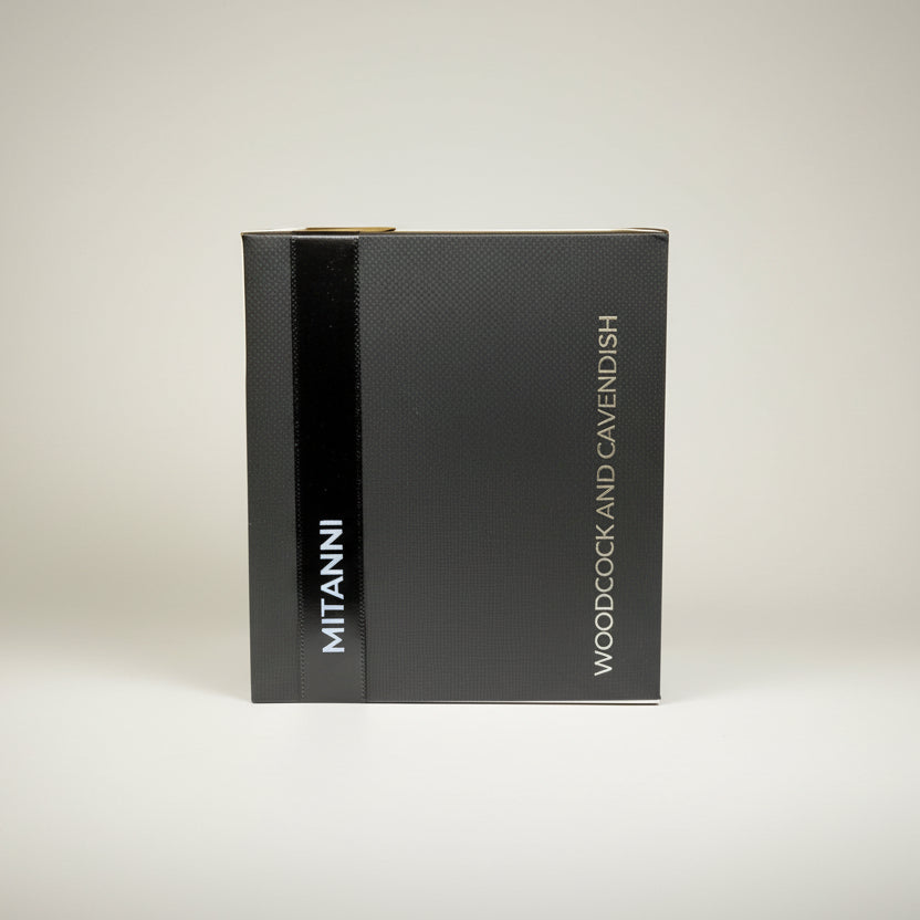 Black textured box with "MITANNI" and "WOODCOCK AND CAVENDISH" in white text, set against a gray background.