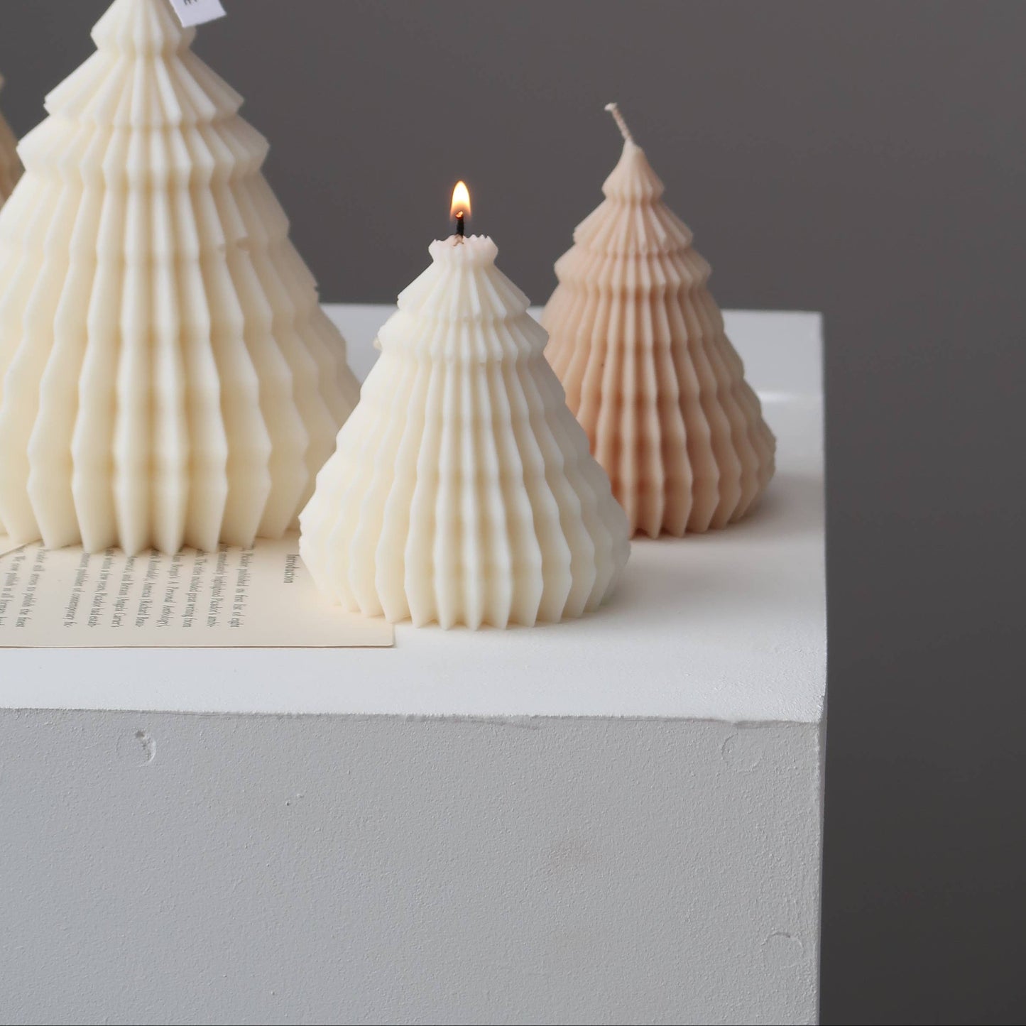 Shell-shaped candles on a white surface with a dark background
