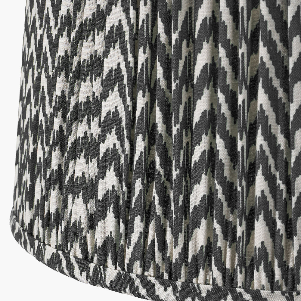 Black and white zigzag pattern on textured fabric with vertical pleats.
