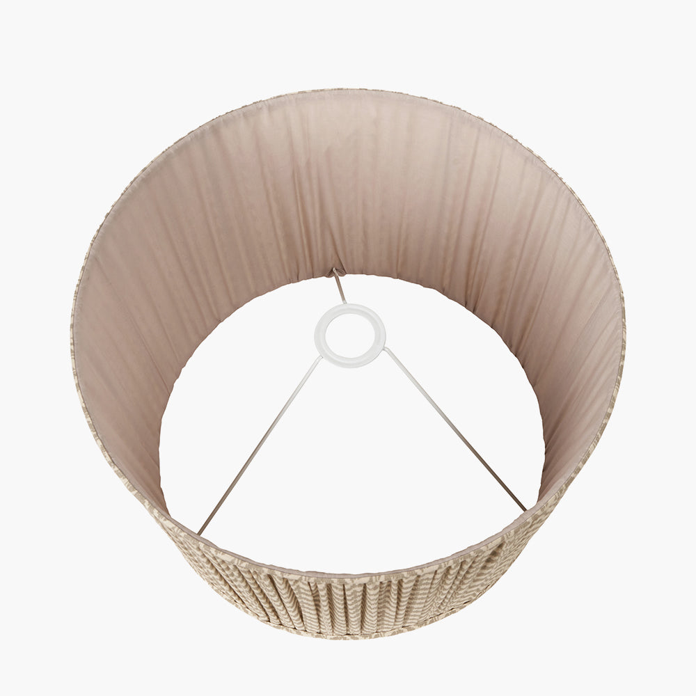 Aerial view of a beige woven lampshade with a white metal frame and light fabric interior.