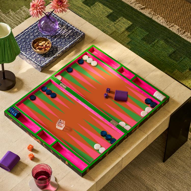 Backgammon board game on a table with decorative items.
