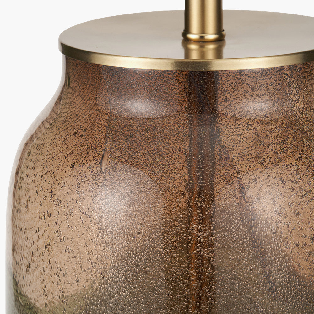 Close-up of a textured bronze vase with a gold base on a white background