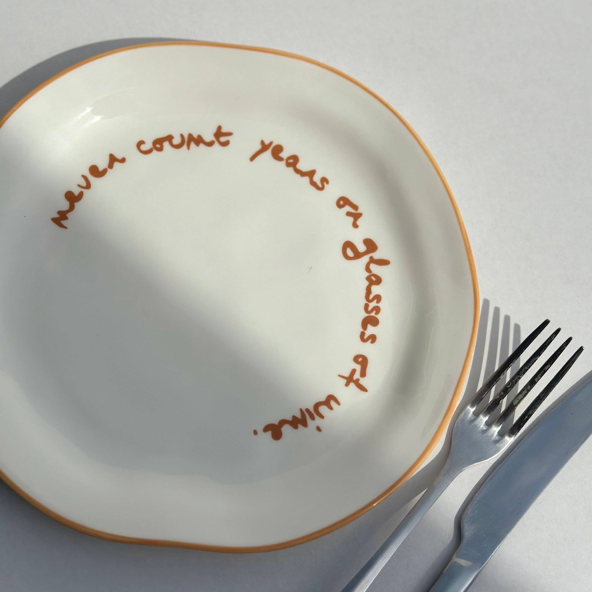 White plate with brown text and a fork on a white background