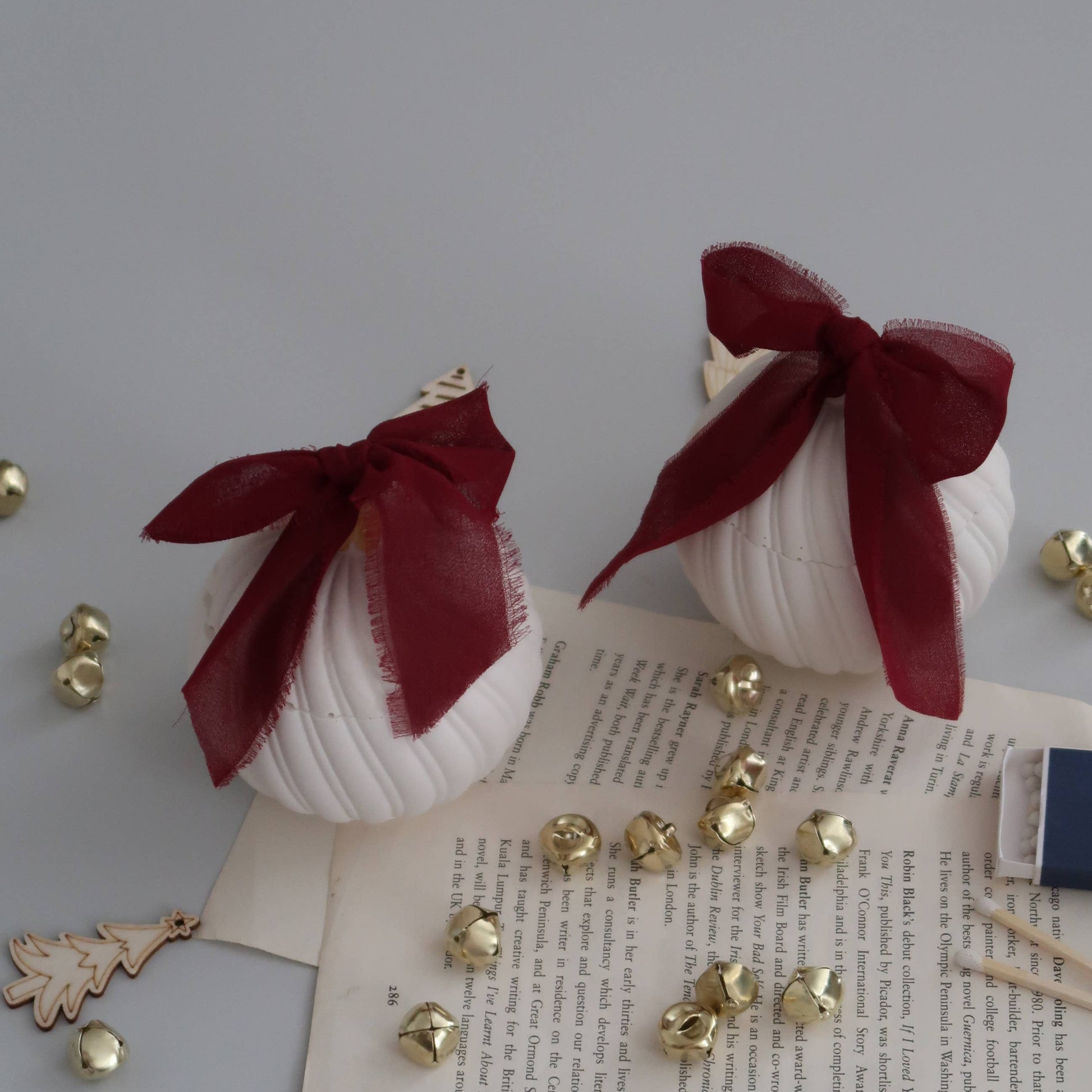 Decorative items with red ribbons and gold accents on a textured surface