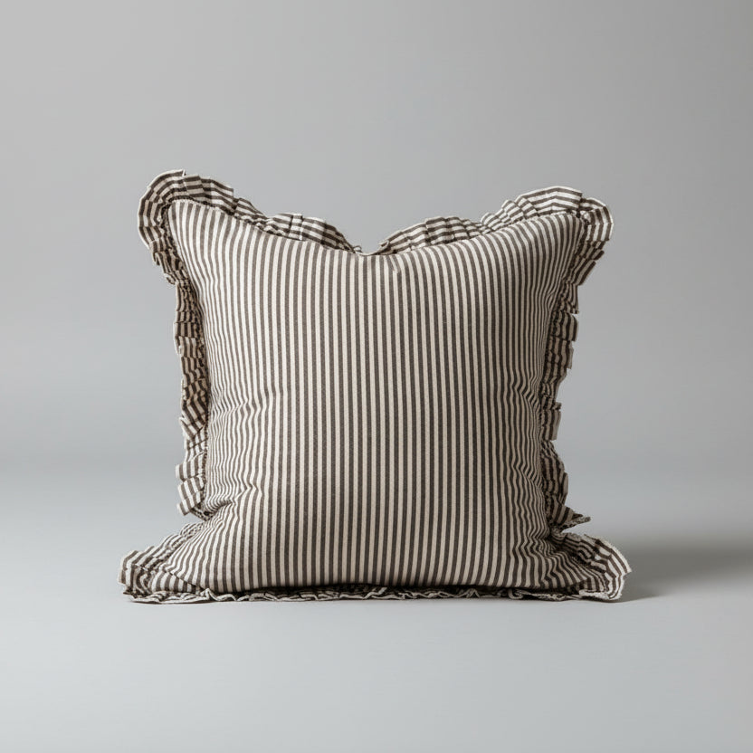 Striped pillow on a wooden surface with a neutral background