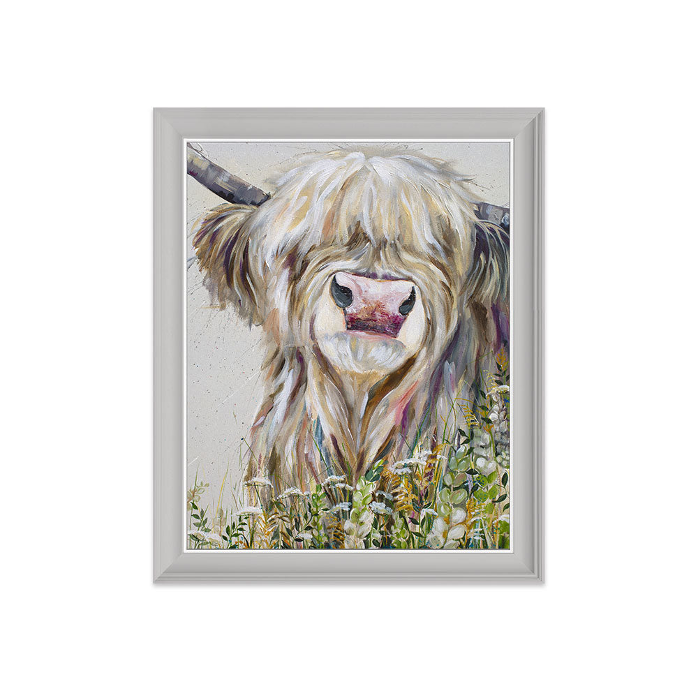 Framed artwork of a highland cow in a field on a white background