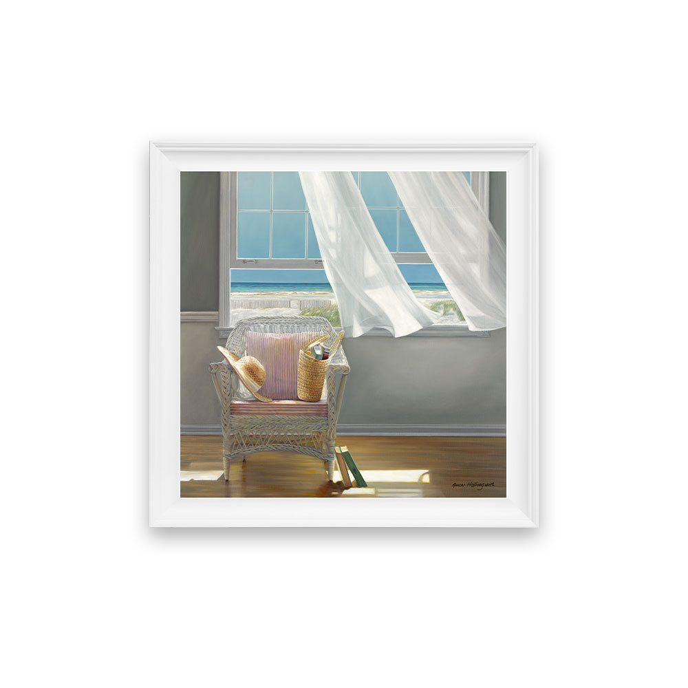 Framed artwork of a wicker chair with a pillow by a window with white curtains.