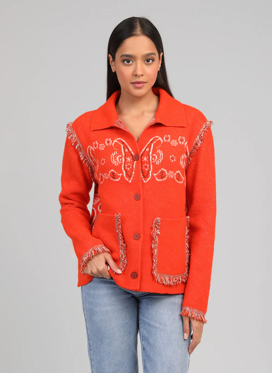 Woman wearing a red embroidered jacket on a gray background