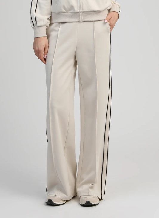 Person wearing a beige outfit with black stripes on a white background