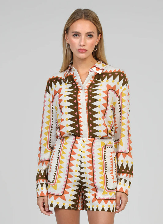 Woman wearing a patterned outfit on a gray background