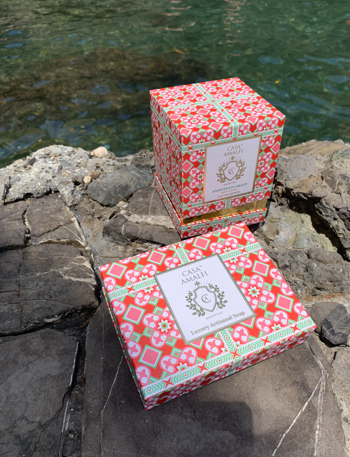 A luxury hand-painted ceramic candle with blue and white stripes, scented with bitter orange and mint, inspired by the Amalfi Coast.