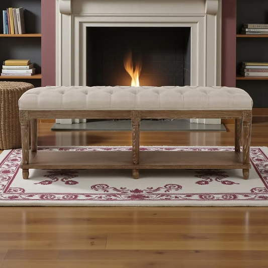 122cm long linen upholstered stool with button-tufting and carved wooden legs in a neutral interior setting.