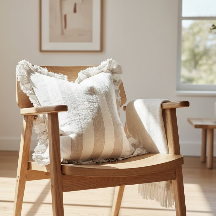 Striped pillow with ruffled edges on a wooden surface against a light background