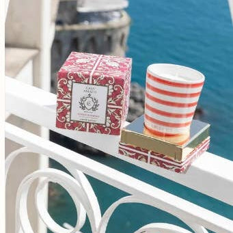 Candle and packaging on a railing with a scenic background