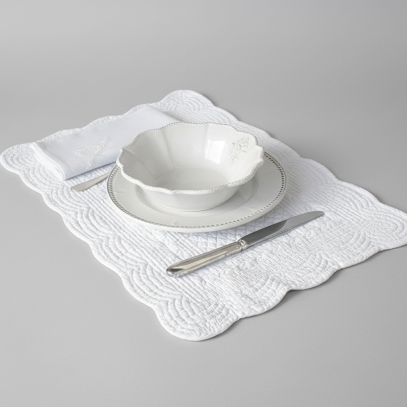 White lace placemat on a wooden table with a plate and cutlery.