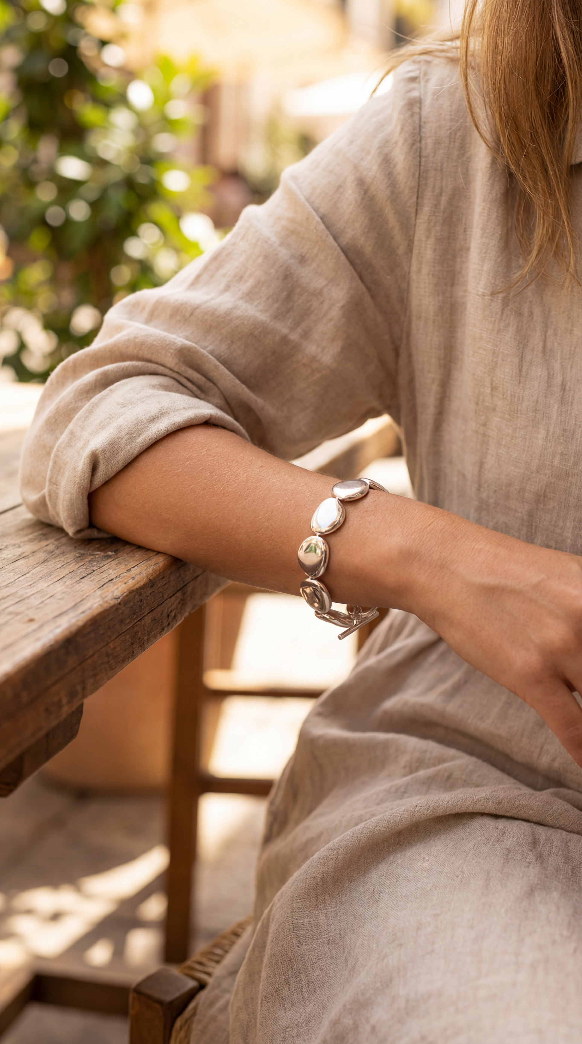 Person wearing a bracelet on a blurred outdoor background